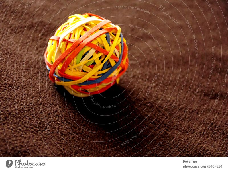 The object of desire - A ball of rubber bands on a brown blanket household rubbers Shallow depth of field Colour photo Deserted Close-up Ball Sphere variegated
