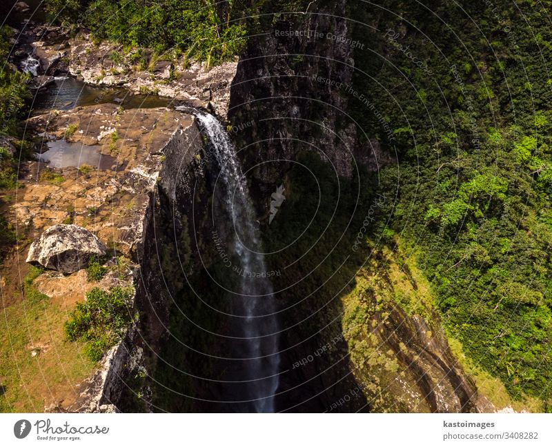 Aerial top view perspective of amazing 500 feet tall waterfall in the tropical island jungle of Mauritius. river cliff mauritius forest africa flowing green