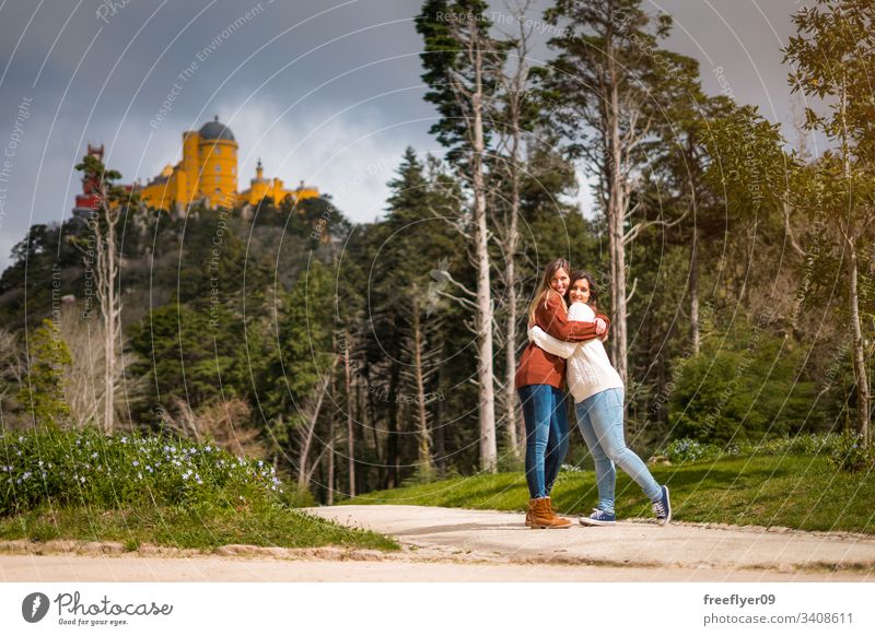 Two friends hugging in front of Pena Palace in Sintra, Portugal building national landmark europa portugal history traditional sintra tree antique mountain