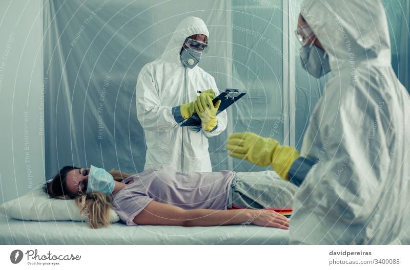 Doctors with bacteriological protection suits examining a patient isolation quarantine medical check covid-19 coronavirus respiratory virus treatment doctor