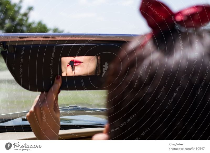 Woman rubbing lipstick in the car Lipstick Red vintage Rear view mirror car mirrors Make-up Mirror Convertible Hand fingernails Nail polish Landscape format