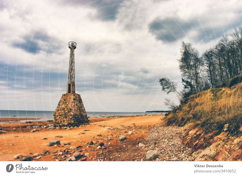 Old ruined lighthouse in the Baltic background beach water architecture moss navigation old outer port rocks shore stock striped structure tower travel tuja sea