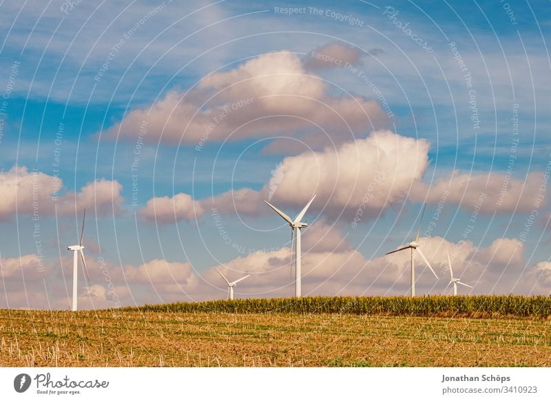 ecological renewable green energy wind power station on a field in evening sun alternative background blue change clean climate change cloud countryside