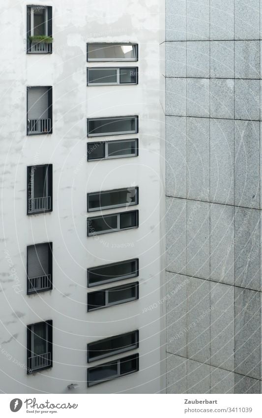 Facade of a high-rise building with windows in portrait and landscape format and granite slabs in light grey High-rise House (Residential Structure)