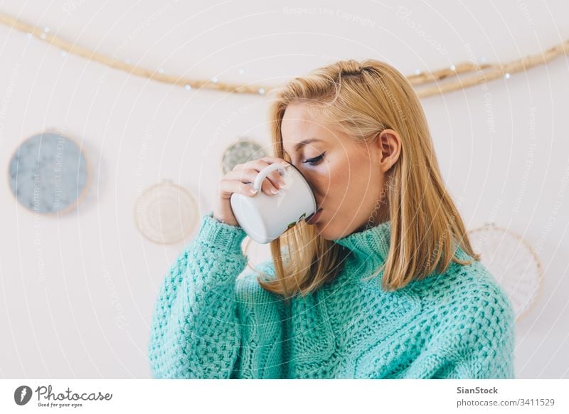 Young pretty girl  drinking coffee woman tea young cup sweaters blonde morning portrait happy beautiful female wall dreamcatcher sunday women home lifestyle