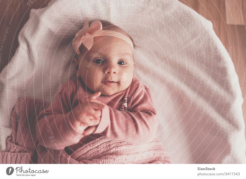 Little cute baby girl lying in basket bed white little newborn home young child Portrait infant kid childhood top view adorable beautiful pink healthy crib