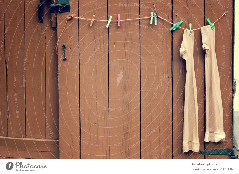 lonely ladies stockings on makeshift clothesline at an entrance gate Stockings Clothes peg Funny Retirement pension Housekeeping Household item Dry Nylon