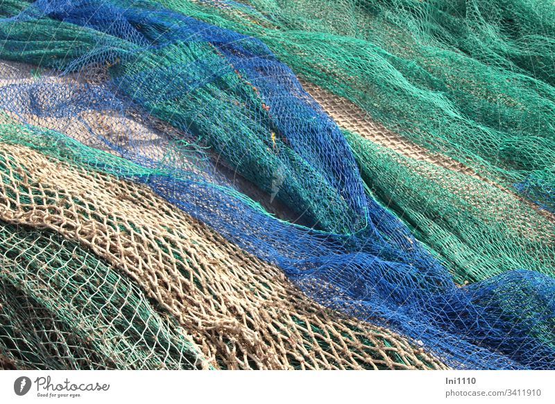 rope team  colourful fishing nets with thick coloured ropes and fishing  balls lie on quay wall - a Royalty Free Stock Photo from Photocase