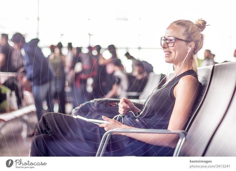 Female traveler using her cell phone while waiting to board a plane at departure gates at asian airport terminal. woman flight young girl destination trip