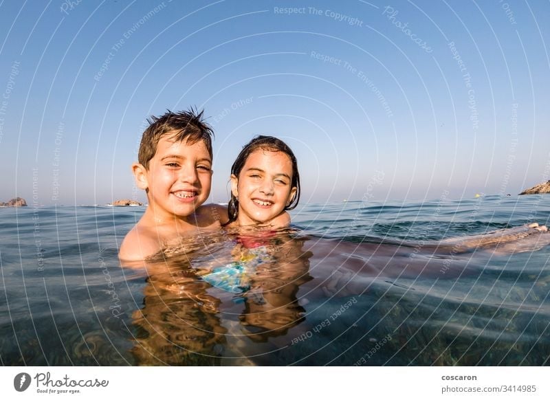 Two little kids playing into the sea active beach beautiful blue boy boys child childhood children cute emotional enjoy excited face family fresh fun happiness