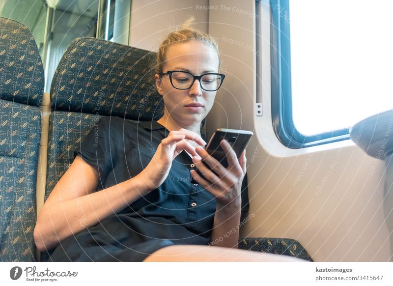 Caucasian female traveler using mobile phone applications while traveling by train. woman transport young passenger smart lady happy trip cellphone