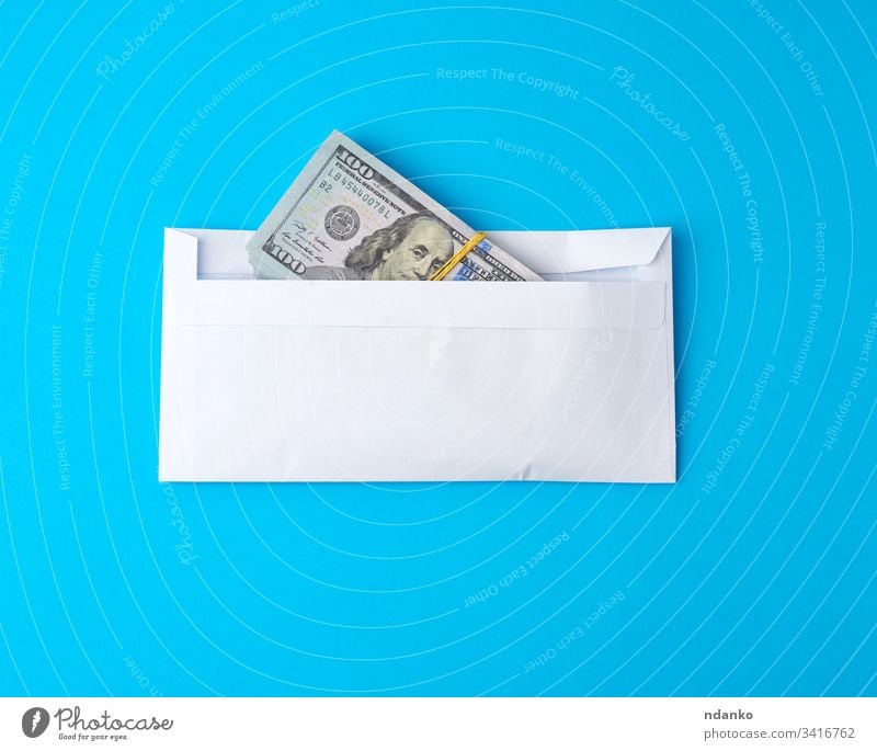 pack of paper American one hundred dollar bills tied with an elastic band and lies in a white envelope money business finance background currency cash bank