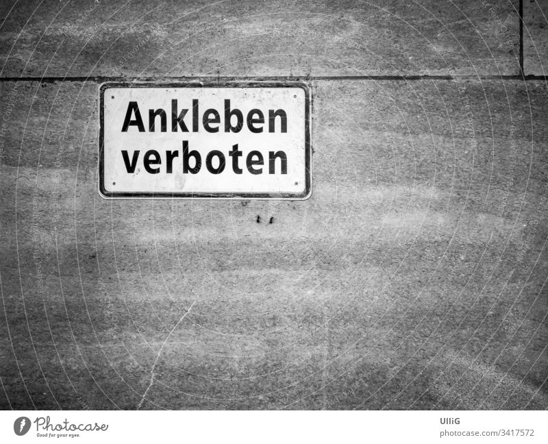 German prohibition sign saying "Ankleben verboten" - No sticking allowed", amusingly stuck to a stone wall, with copy space. text interdiction forbidden