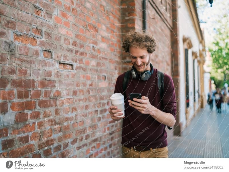 Young man using his mobile phone. person adult male young people outside handsome happy cell attractive technology casual lifestyle urban city smartphone