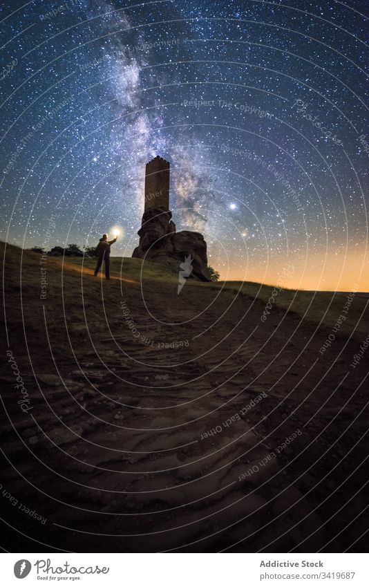 Unrecognizable tourist exploring old ruins at night explore traveler sightseeing remain ancient castle milky way abandoned ruined architecture medieval galaxy