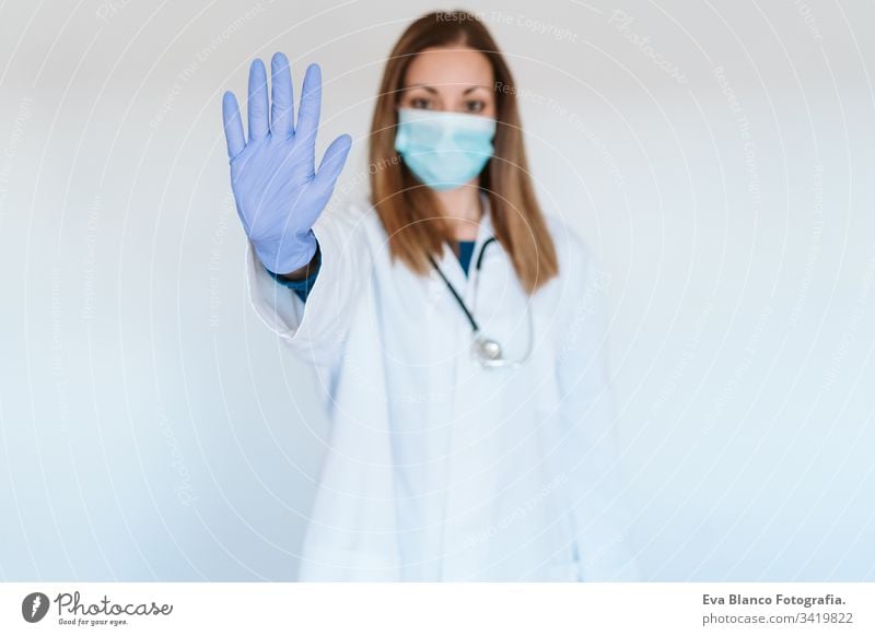 portrait of doctor woman wearing protective mask and gloves indoors. Making a stop sign with hand. Corona virus concept professional corona virus hospital