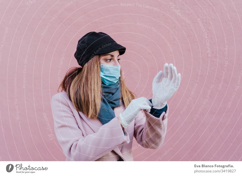 caucasian woman in the street wearing protective gloves and using mobile phone. corona virus concept mask outdoors technology internet public adult infection