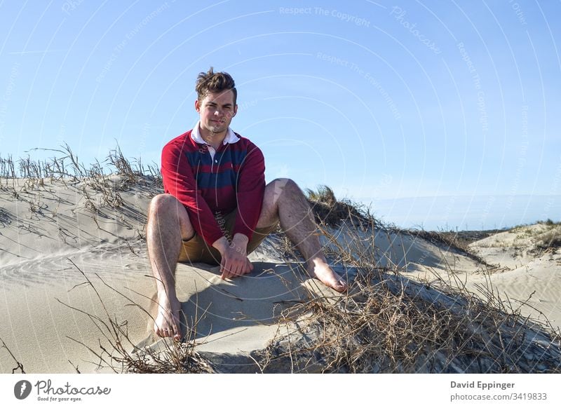 Guy in a red and blue rugby shirt sitting on sand dunes Beach Beach dune Sand Vacation & Travel Coast Dune Ocean Relaxation