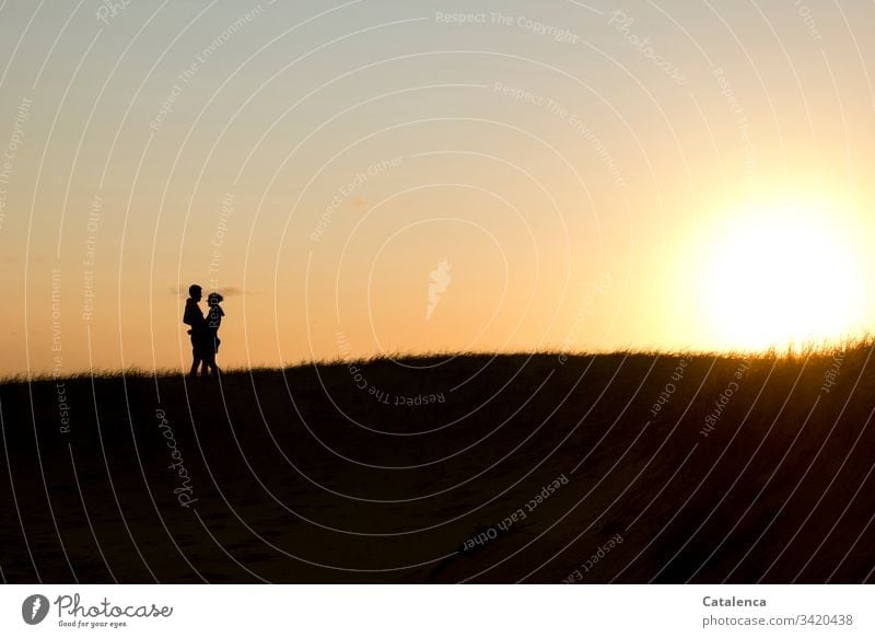 The sun sets on the horizon, on the left the silhouette of an embracing couple Sunset Couple Twilight Evening Clouds Sky Dusk Nature Landscape Exterior shot