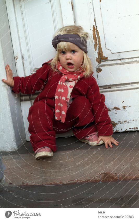 Small, blond, talking girl in winter clothes, climbs a staircase, in front of an old, white wooden front door. Child Toddler Playing Joy Infancy Cute 1