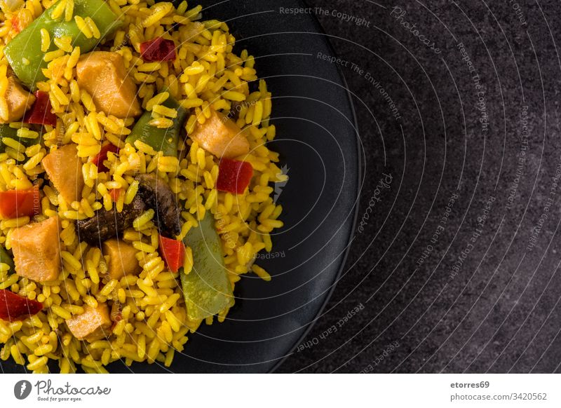 Fried rice with chicken and vegetables on black plate. Top view. Copy space asian chinese cooked cuisine delicious dish food fried frying pan grain green meat