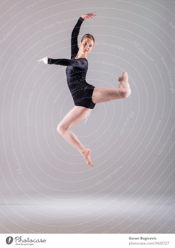 Beautiful female ballet dancer on a grey background. Ballerina is