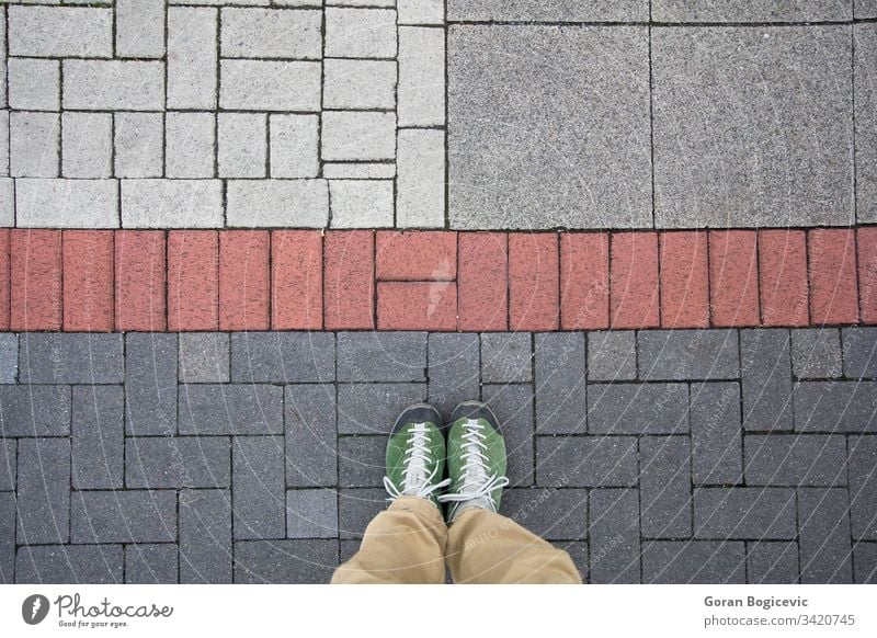 Top view of a man standing on the colorful geometrical pavement street outdoor foot travel floor stone ground shoe person sidewalk lifestyle urban city road pov