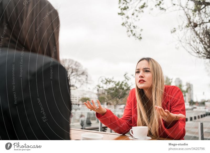 Two angry friends discussing while sitting at coffee shop. two discussion talking woman friendship complicated negative problems girls speaking worried argument