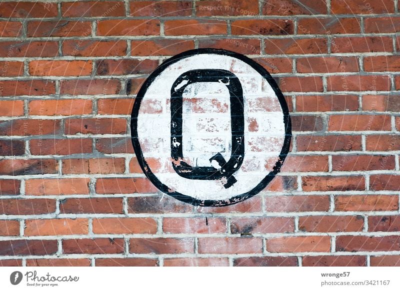 Large black Q on white background on a brick wall q Letters (alphabet) Colour photo Day Characters Exterior shot Capital letter sign Brick wall Building