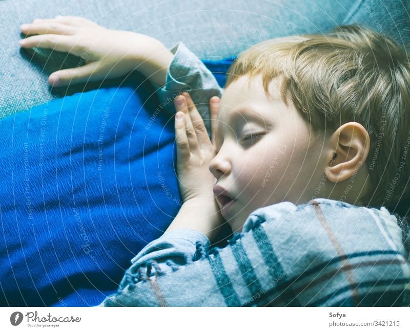 Little blonde boy sleeping under a blanket little child blue bed childhood pillow cute dream kid rest bedtime relax asleep lying face sweet nap peaceful sleepy