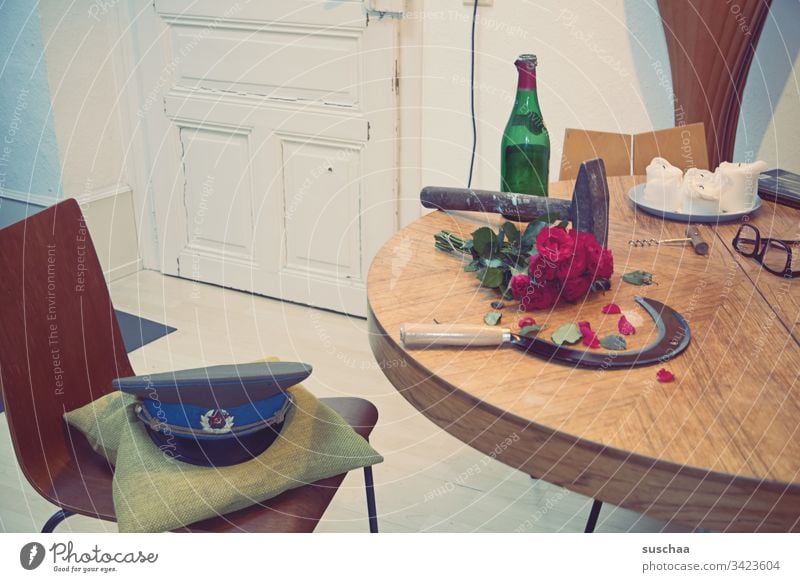 hammer and sickle lying on a table, together with an empty wine bottle, a bouquet of red roses and a military cap Photochallenge Hammer Table Kitchen