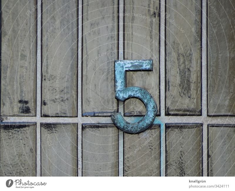 Wrought-iron house number 5 on grey-green glazed clinker brick slips House number Digits and numbers Detail Pattern Wall (building) Exterior shot Facade