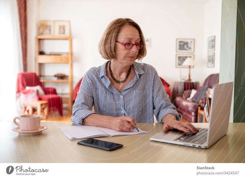 Middle Age Senior Woman Working At Home Using Computer A Royalty