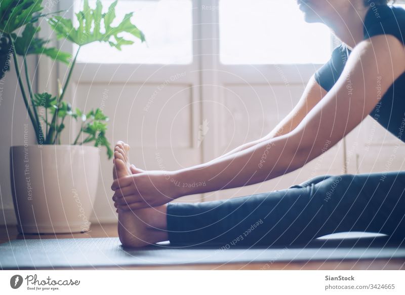 Young woman doing online yoga at home. Online fitness, home