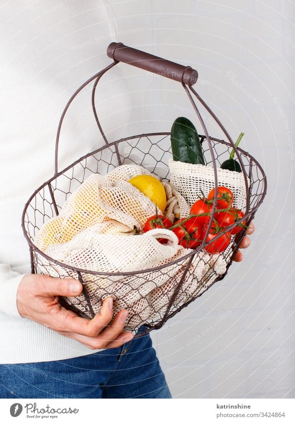 Woman keeps backet with vegetables and fuits in bags Zero waste jar glass jar basket concept body woman hands faceless textile farmers close up zero food