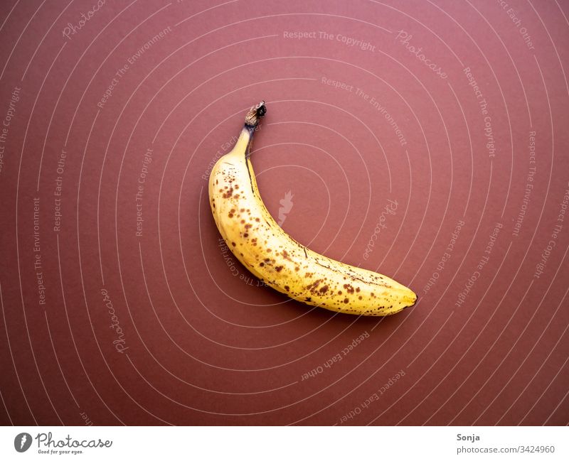Überreife Banane mit Punkten auf einem braunen Hintergrund überreif punkte hintergrund draufsicht noch gut wegwerfen Lebensmittel Detail Food Organic produce