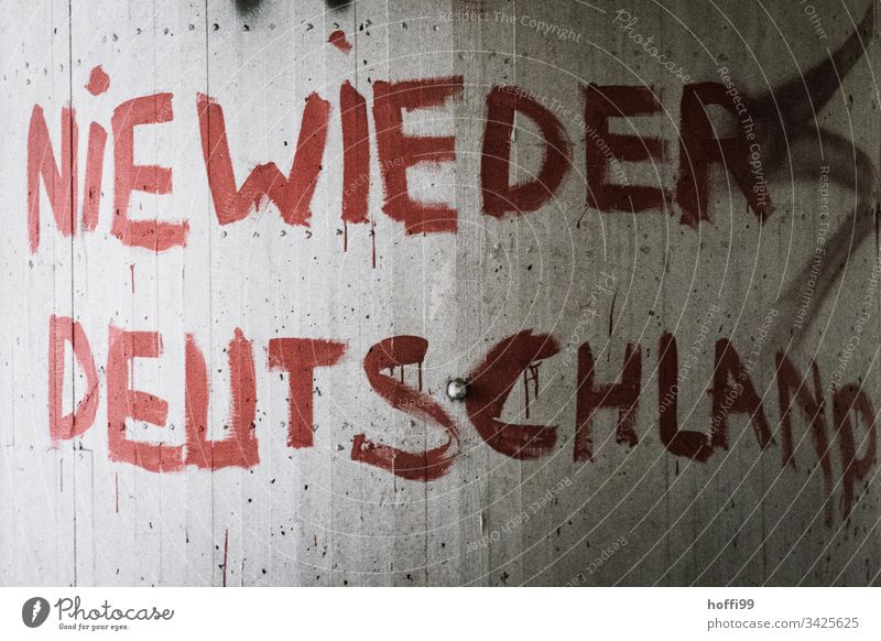 Slogan on the wall - Never again Germany Sign Way out Politics and state Criticism Red writing Strings Remark Characters Deserted Graffiti Society Exterior shot