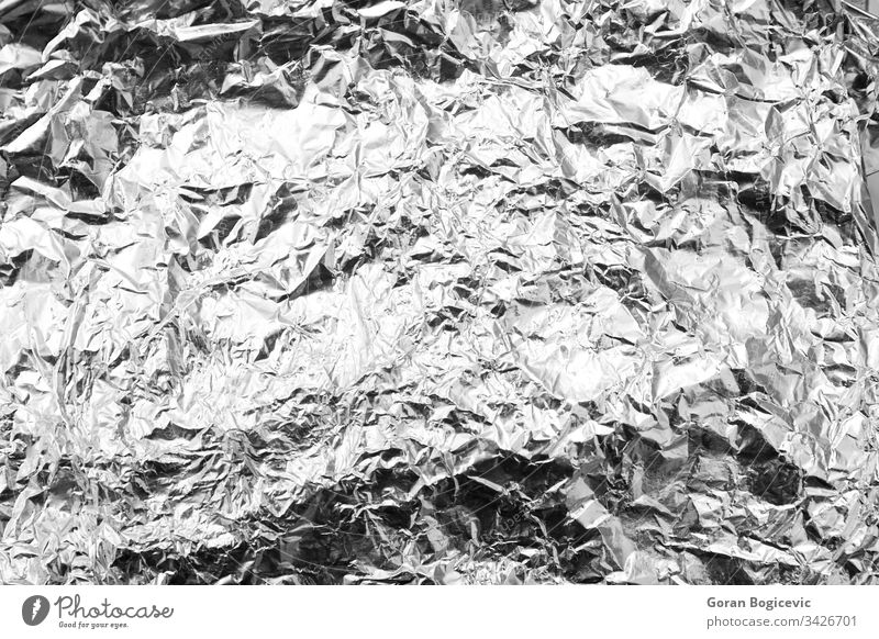 Close up of a wrinkled aluminum foil sheet silver gray shiny aluminium abstract paper texture background closeup alloy crumpled shine textured chrome backdrop
