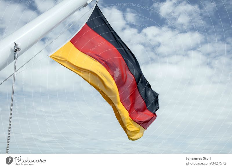 German flag in the wind Flag Germany Black Red Gold Cloth Wind ship Flagpole Rope Sky cloud Public Holiday Celebration Pride nation Company unit fatherland