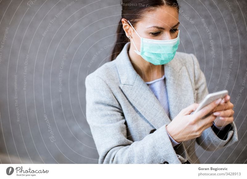 Pretty young woman with protective facial mask on the street virus health contagious safety epidemic phone disease mobile coronavirus pandemic flu medical