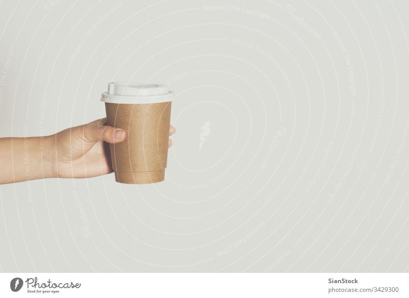 Womans hand holding brown paper cup of hot coffee. isolated white drink woman background disposable cafe lid container caffeine breakfast icon design drinking