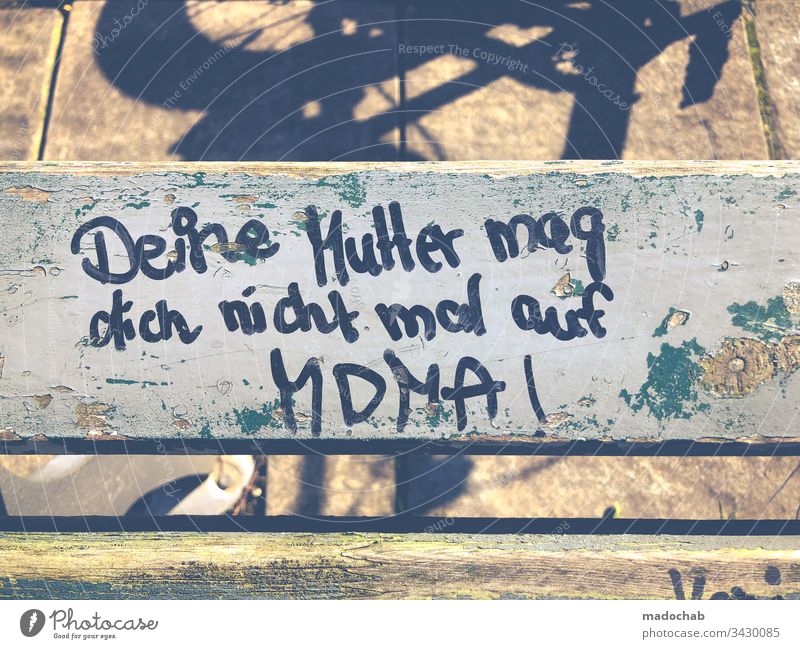 Youth culture mobbing - Saying scribble on park bench: Your mother does not like you even on MDMA saying youthful harassment Youth (Young adults) teenager