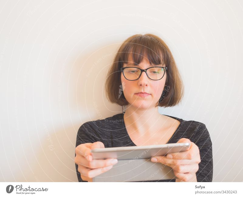 Caucasian woman with glasses using tablet gadget sitting caucasian portrait middle work home quarantine bob horizontal aged internet room technology copy space