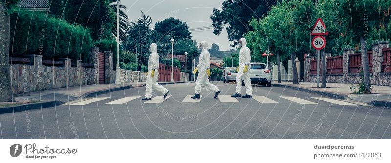 People in bacteriological protection suits walking down an empty street covid-19 coronavirus curfew quarantine crosswalk pandemic epidemic outdoor banner web