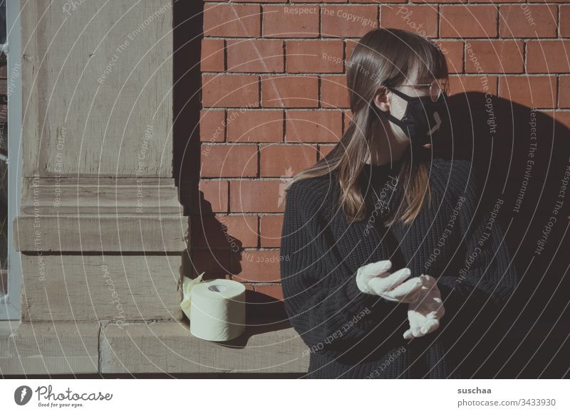 teenager with face mask on a house wall with toilet paper | corona thoughts Youth (Young adults) Young woman at home home office Eyeglasses stay at home Crisis