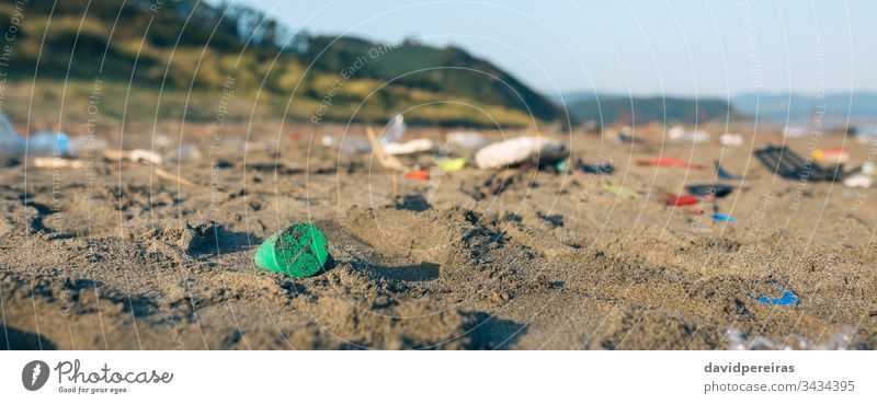 Dirty beach landscape full of waste trash garbage plastic sand dirty contaminated environment nature pollution banner web panorama panoramic coast plastic lid