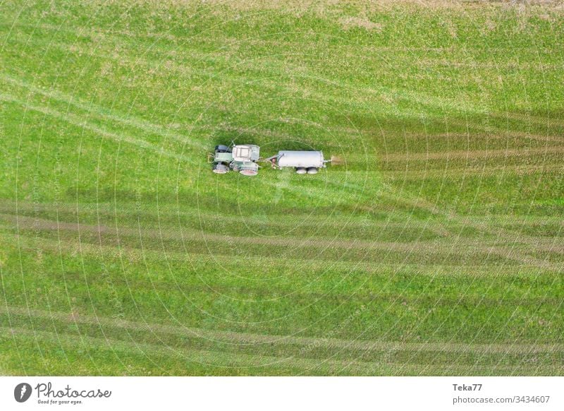 tractor spraying cow dung from above farming tractor agriculture agricultural meadow field grass modern modern agriculture modern machine farming machine