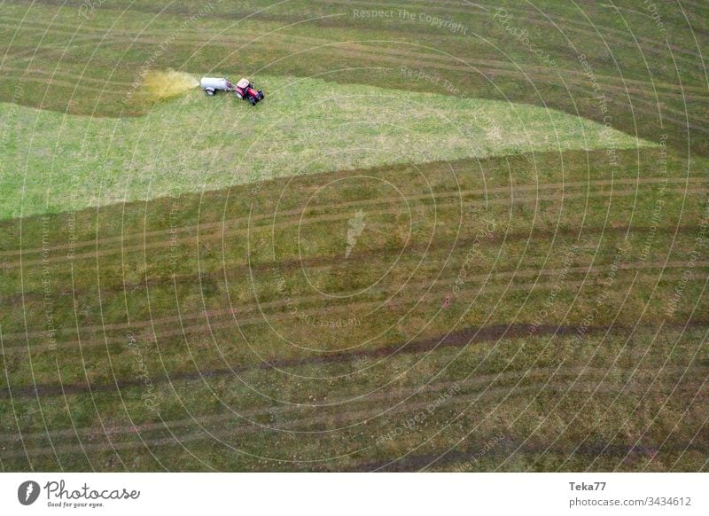 tractor spraying cow dung from above #2 farming tractor agriculture agricultural meadow field grass modern modern agriculture modern machine farming machine