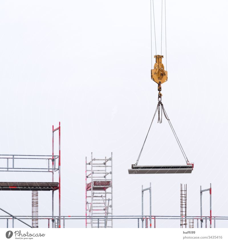 Suspended concrete elements on the load hook of a crane Construction site Crane ladder construction site supply Work and employment Craft (trade) Build