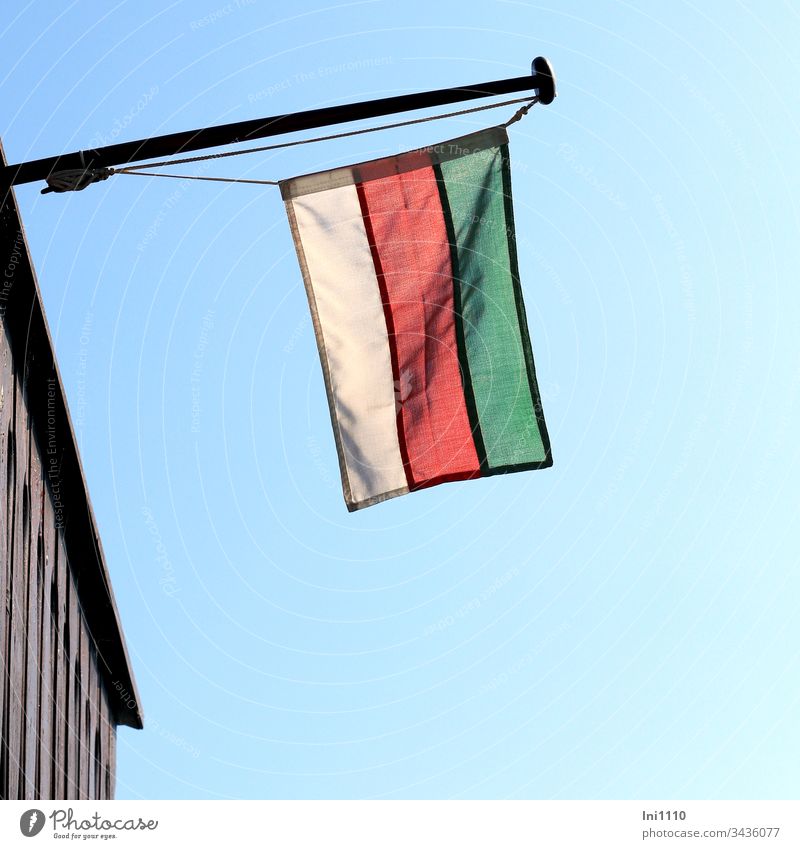 Flag on flagpole with the colours of Helgoland hanging from the building in front of a blue sky Flagpole Blue sky Neutral Background Deserted upside down